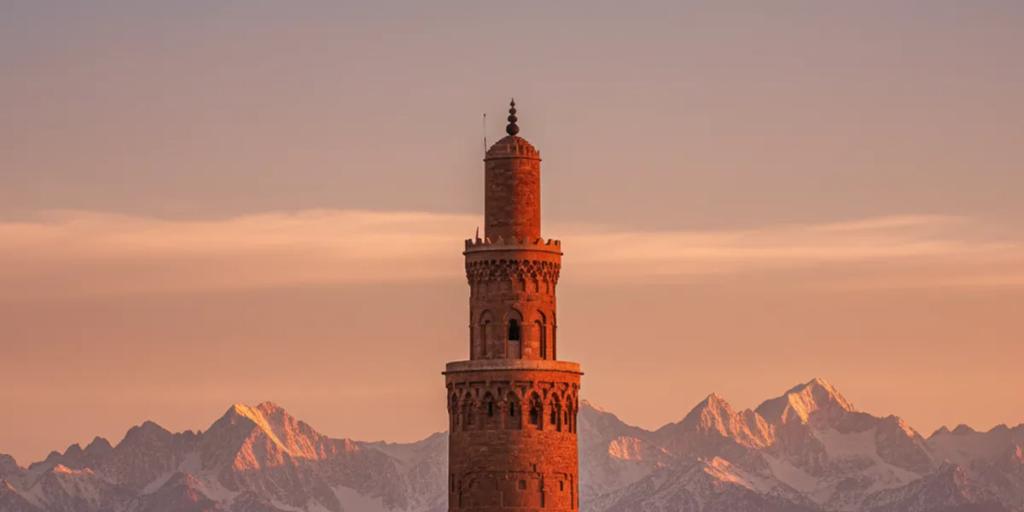 Dächer der Medina von Marrakesch mit dem Koutoubia-Minarett und dem schneebestäubten Atlasgebirge dahinter